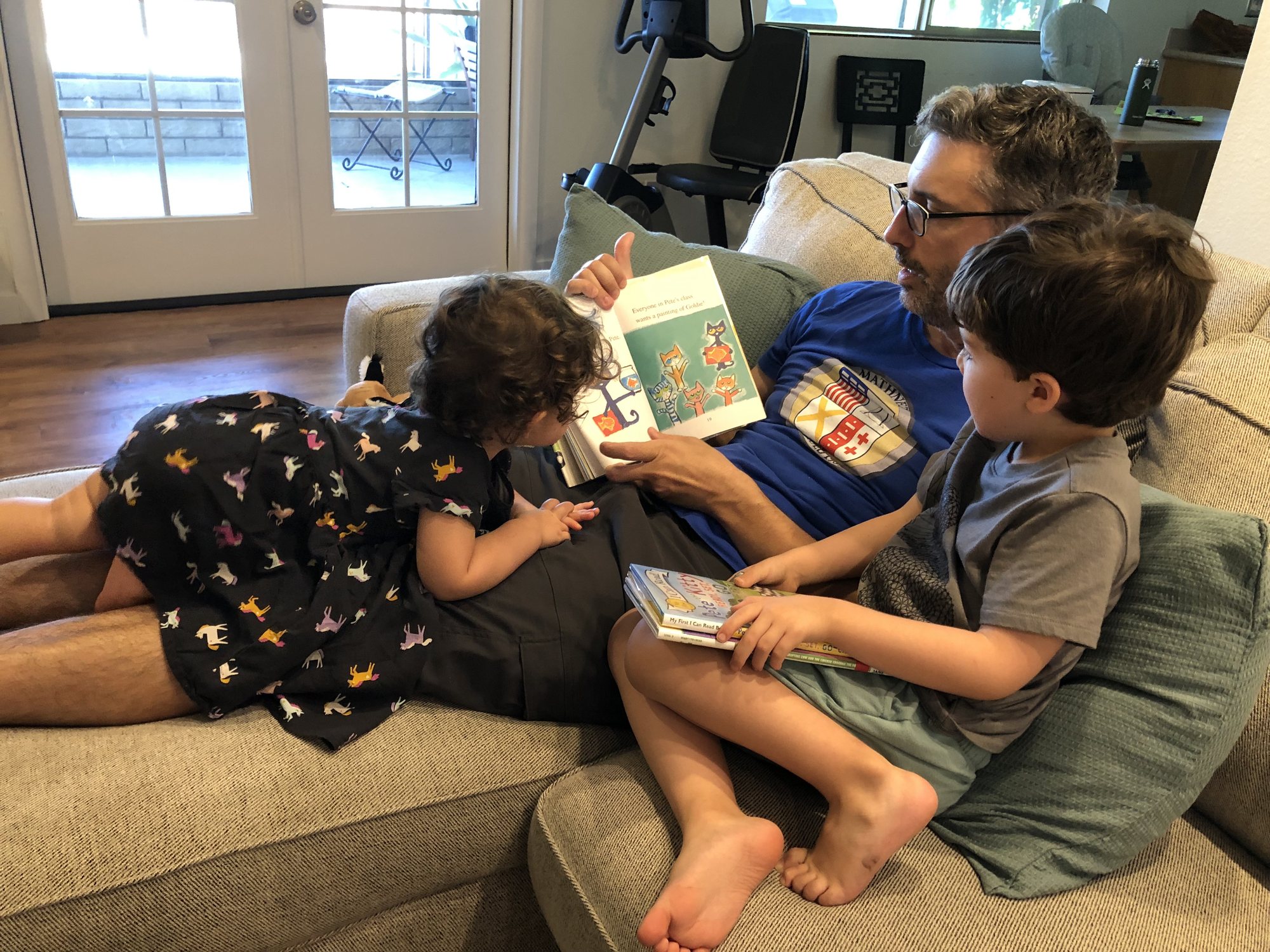 Reading with dad. Notice Nora using his legs as a bed :)