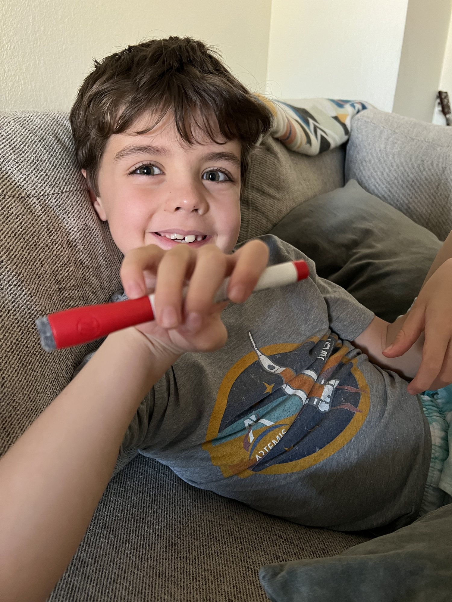 Practicing his bow hold for violin.